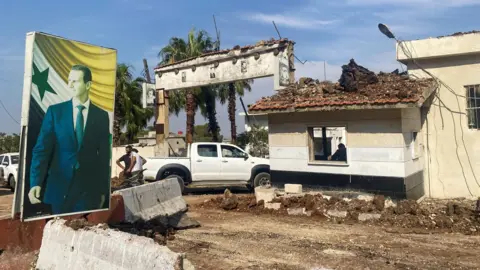 Reuters A poster of Syrian President Bashar al-Assad is seen at a site reportedly damaged in an Israeli strike, in Hama, central Syria (9 September 2024)