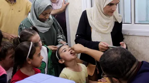 Reuters A girl is given an oral polio vaccine in Jabalia, in northern Gaza Strip (10 September 2024)